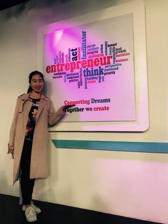 太阳集团tyc5997MBA 学生黄怿箴在丁丁电视创业LOGO处合影留念